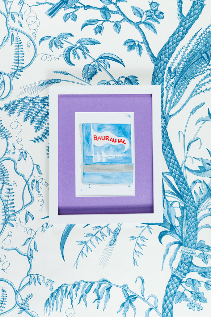 Baur Au Lac Matchbook - Furbish Studio, A Bauraulac matchbook watercolor print featuring sailing boats with a sky blue background color resembling the Bauraulac Hotel's surroundings in a 5x7 white frame with a wallpaper background