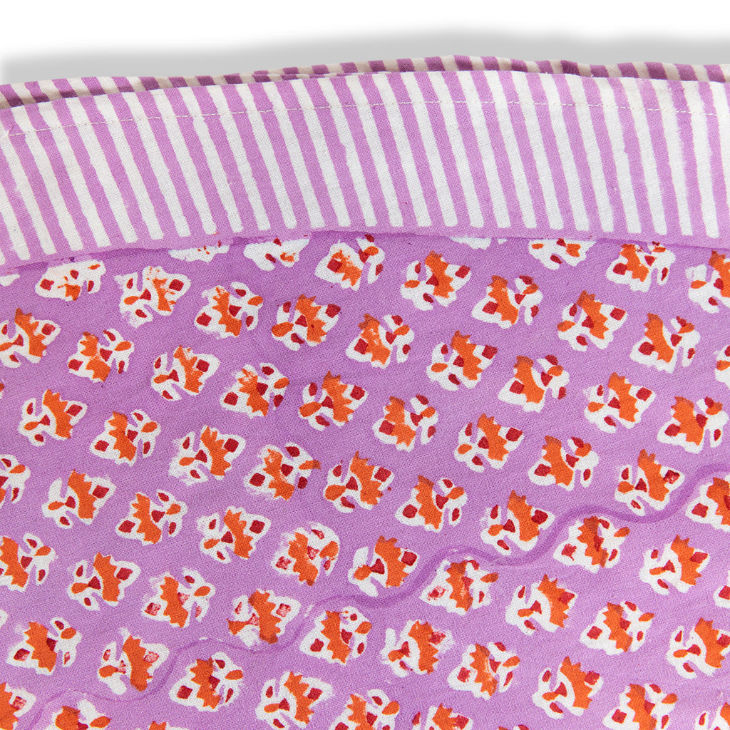 a closer look of lilac block print handmade round table cloth with orange flowers and round edge stripes