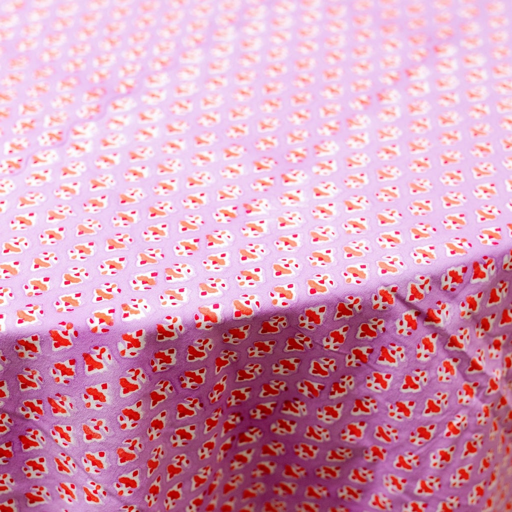 a closer view of lilac block print handmade round table cloth with orange flowers and round edge stripe