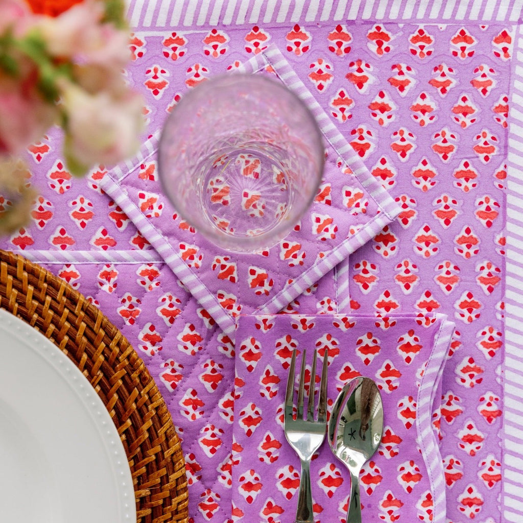 a beautiful table setting showcasing Ambroeus table linens with spoon and fork positioned to the right of the plate, a glass above the silverware and a table cloth beneath all of them