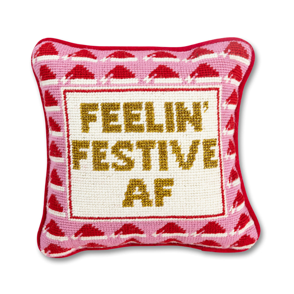 an in-depth view of a hand embroidered in wool and backed in luxe bright red velvet chic needlepoint pillow with "Feelin' Festive AF" cheeky saying in front