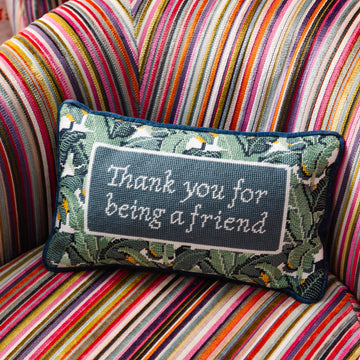 Decorative pillow with 'Thank you for being a friend' text on a striped chair