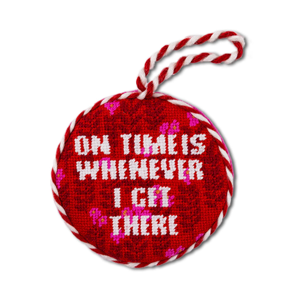 Red ornament with white text and candy cane handle on a white background