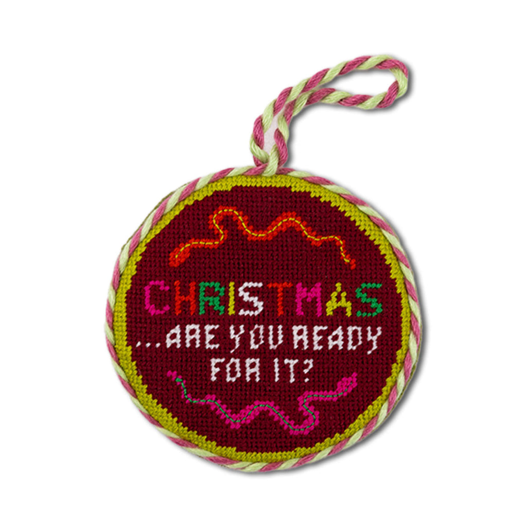 Round embroidered Christmas ornament with text and colorful border on a white background