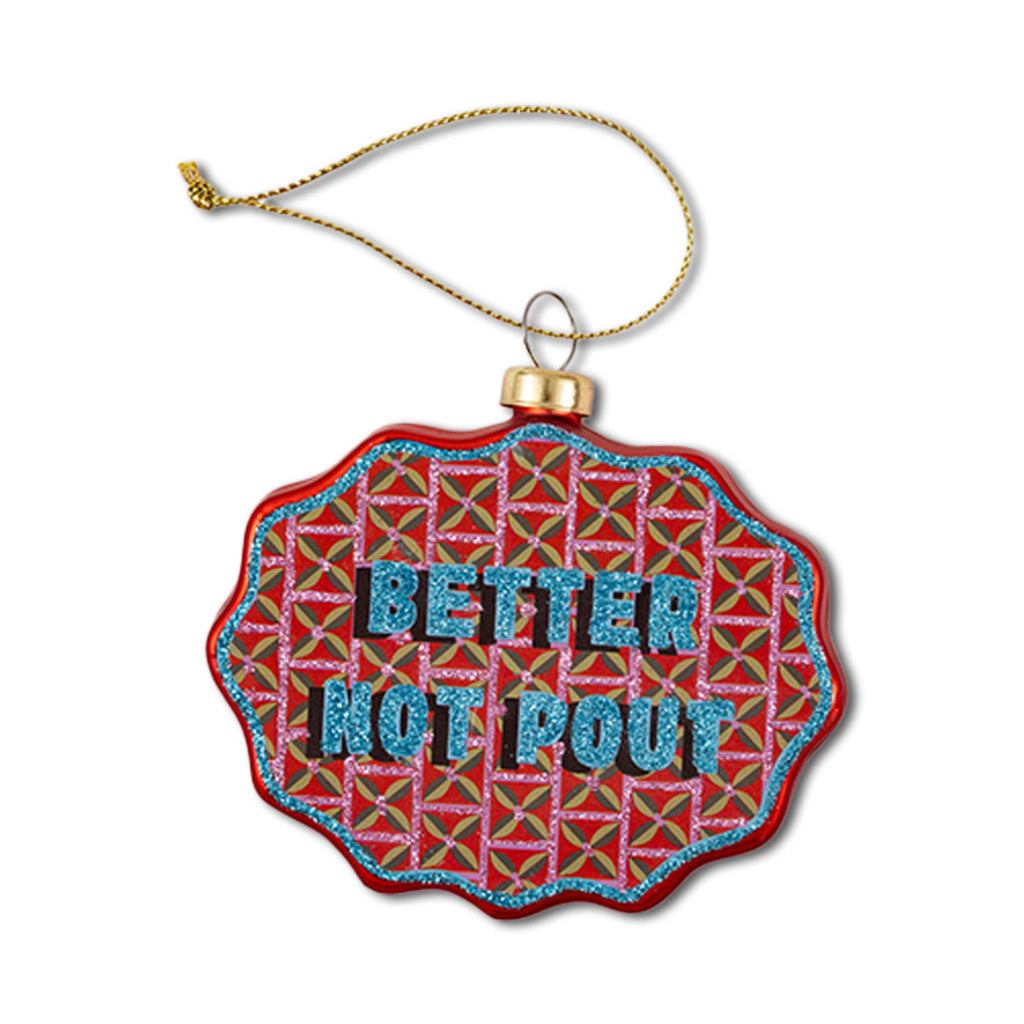 A festive Christmas ornament with a scallop shape, featuring the text 'BETTER NOT POUT' on a red and green patterned background, attached to a decorative loop.