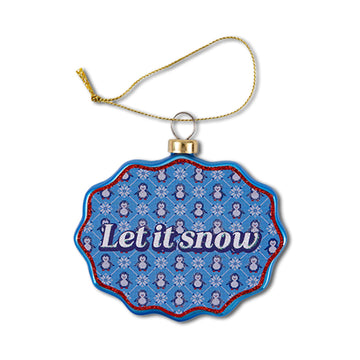 A scalloped glass ornament with a blue and white pattern, featuring the text 'Let it snow' at the center, and a decorative hanging loop.