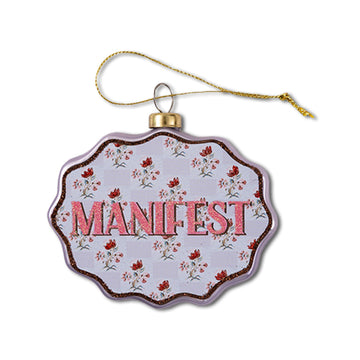 Decorative ornament with 'MANIFEST' text on a floral patterned background