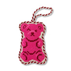 Pink bear-shaped knitted toy with red and white rope on a white background