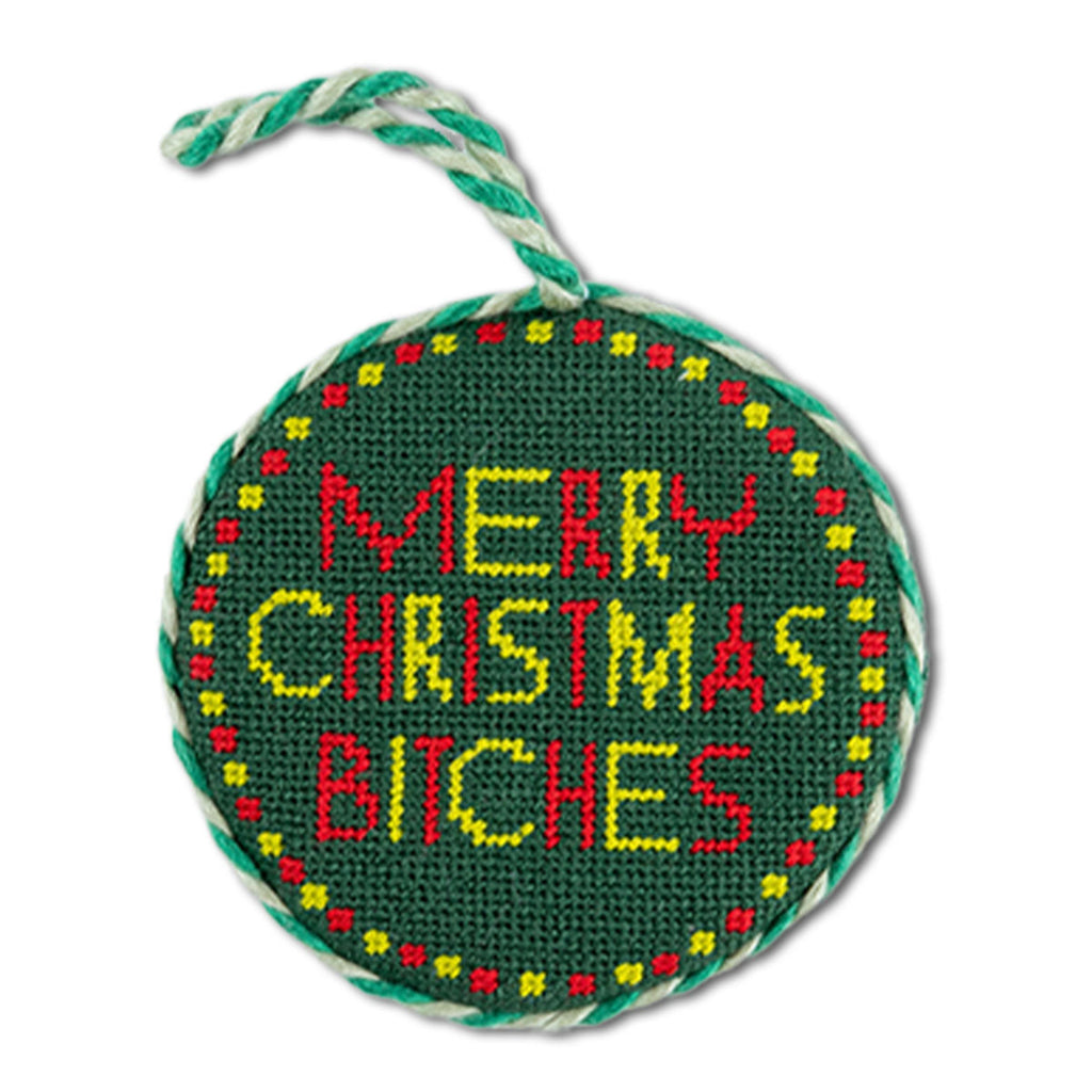 Round green needlepoint ornament with colorful text on a white background