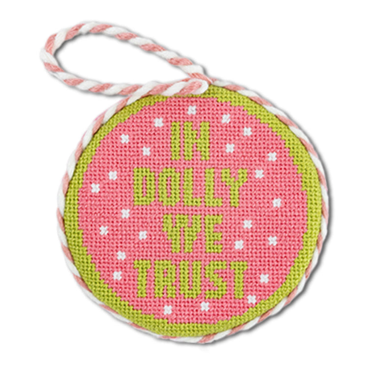 Round pink and green tag with 'In Dolly We Trust' text on a white background