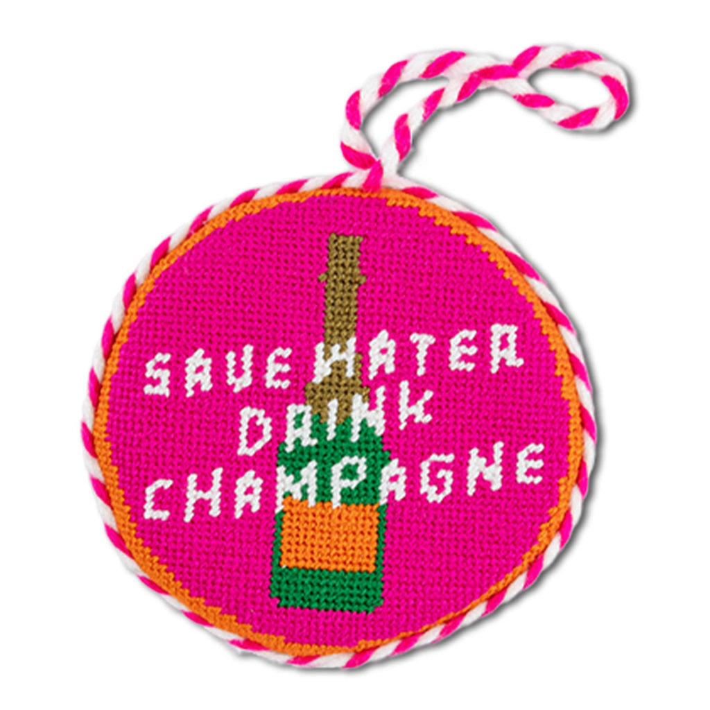 Circular ornament with 'Save Water Drink Champagne' text and champagne bottle design on a pink background.