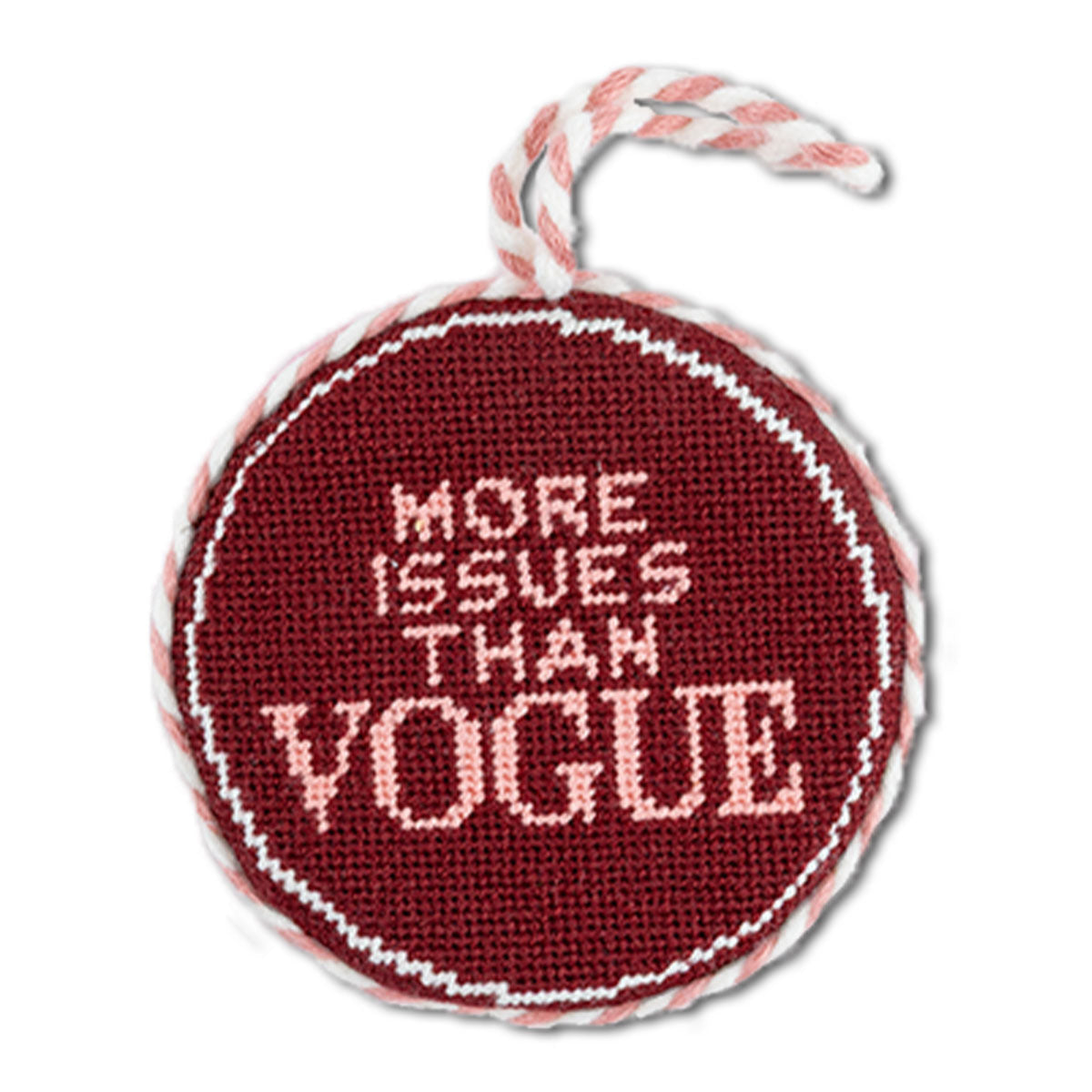 Round needlepoint ornament with 'More Issues Than Vogue' text on a white background