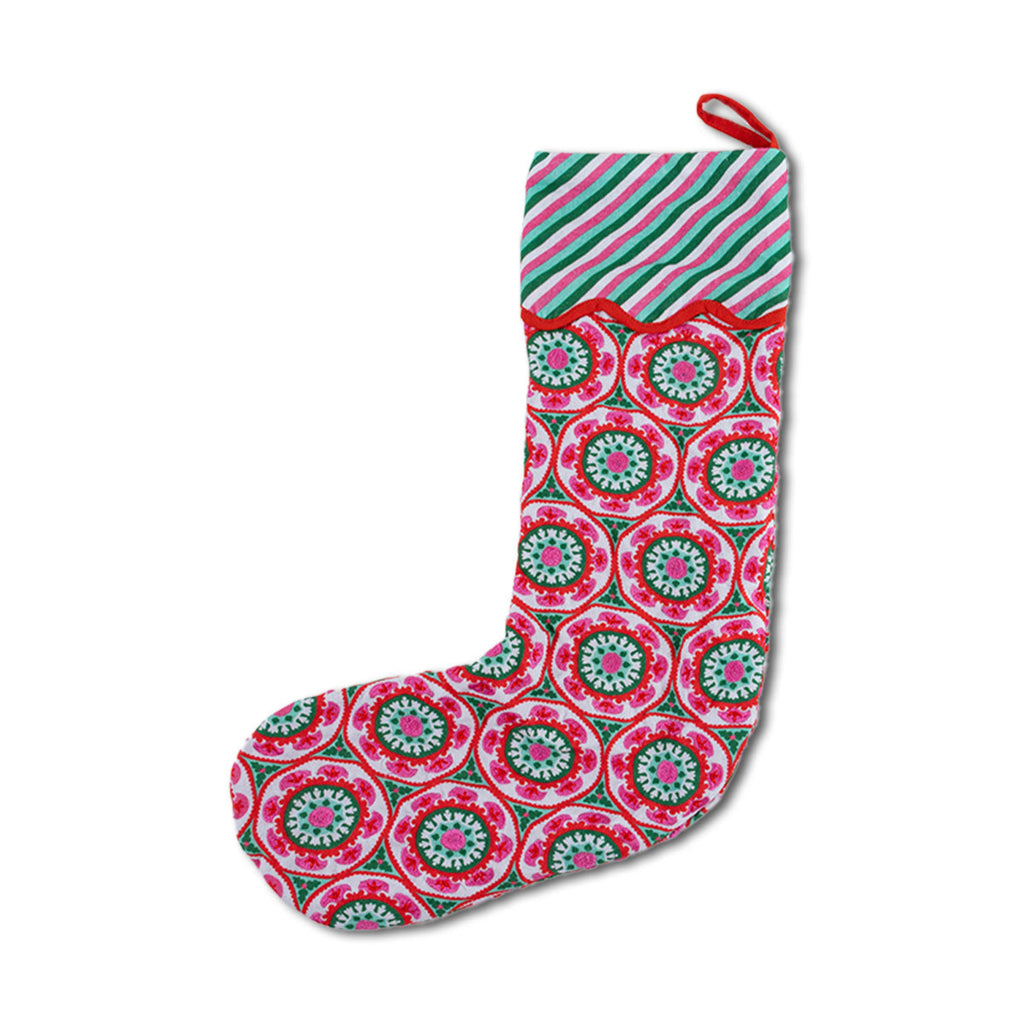 Decorative Christmas stocking with pink and green circular pattern on a white background