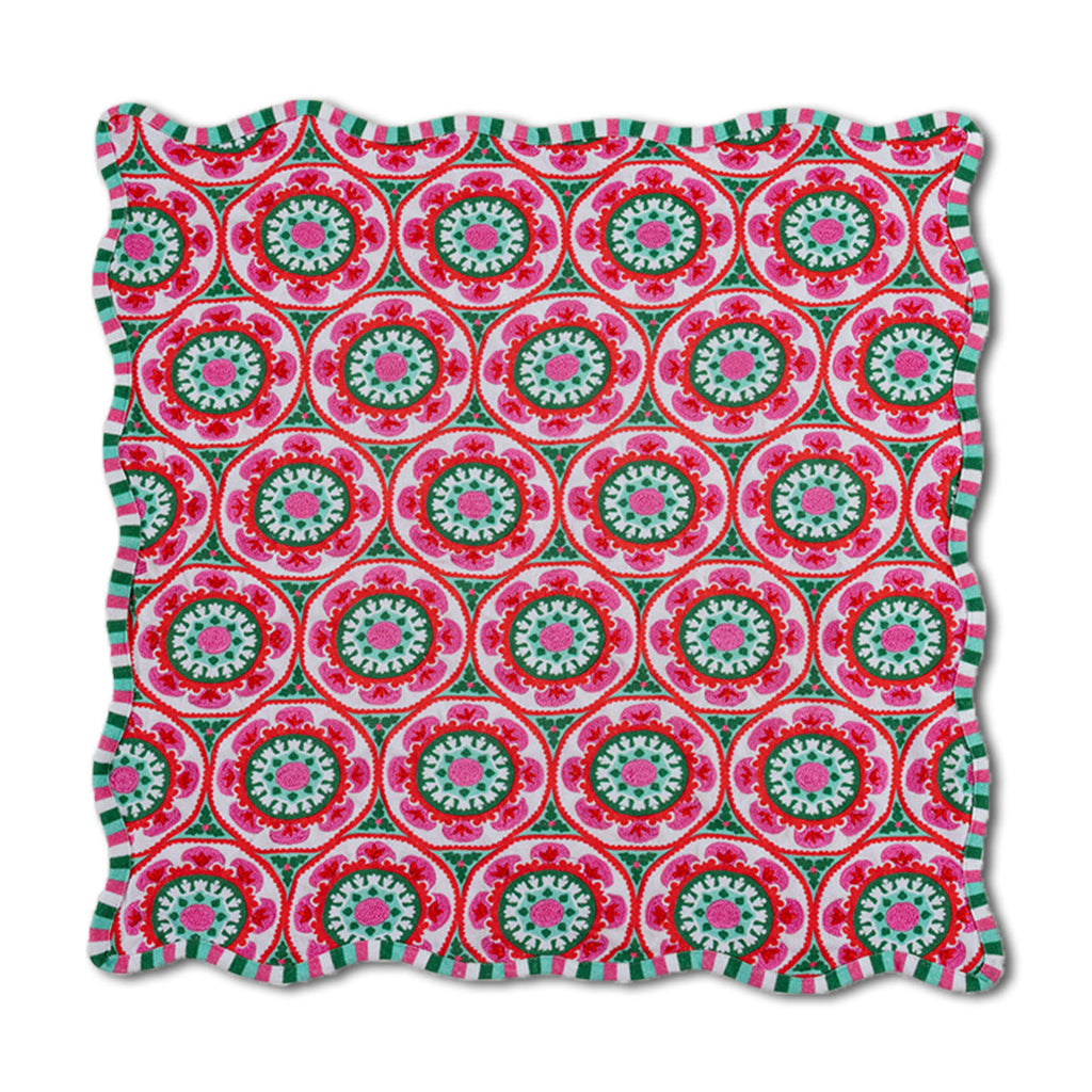 Decorative pillow with a pink and green circular pattern on a white background