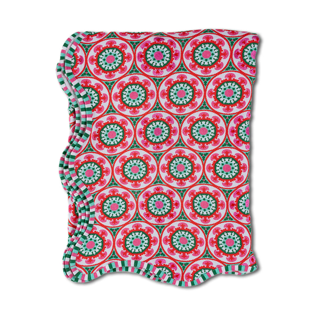 Folded fabric with a pink and green geometric pattern on a white background