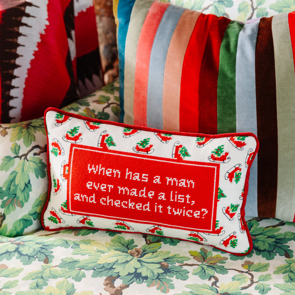 Decorative pillow with a humorous quote on a floral-patterned couch.
