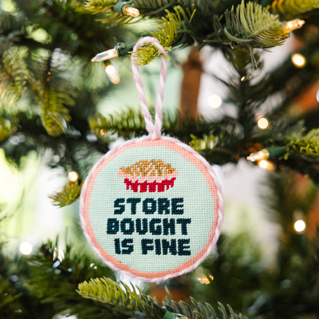 Decorative ornament with 'Store Bought is Fine' text on a Christmas tree.