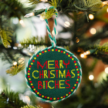Decorative ornament with 'Merry Christmas Bitches' text on a Christmas tree.