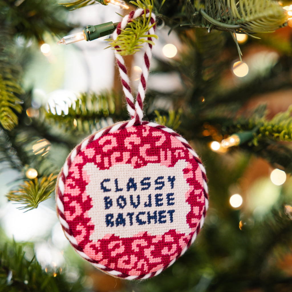 Decorative ornament with text 'Classy Boujee Batchet' hanging on a Christmas tree.