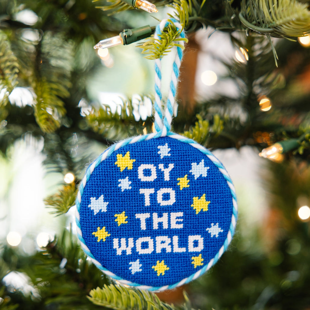 Decorative ornament with 'OY TO THE WORLD' text on a Christmas tree.