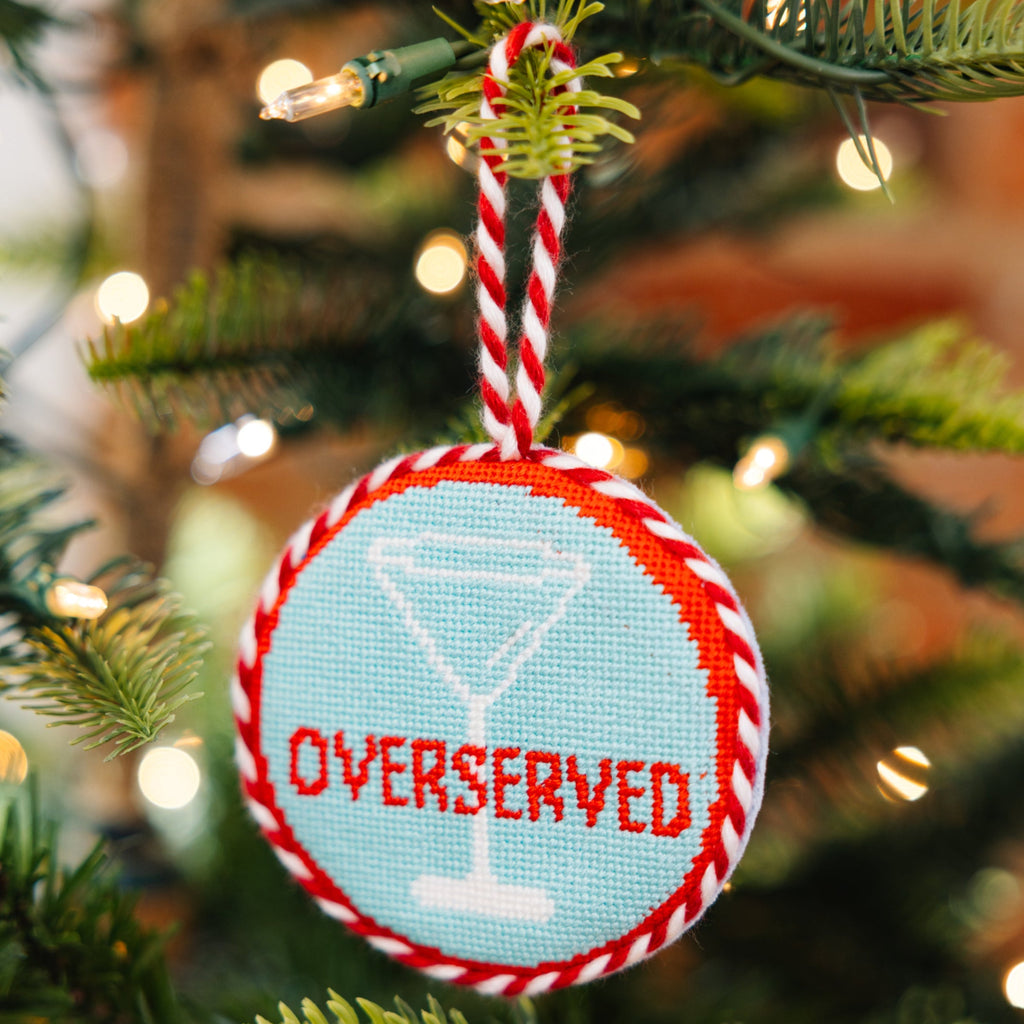 Decorative Christmas ornament with 'Overserved' text on a Christmas tree.