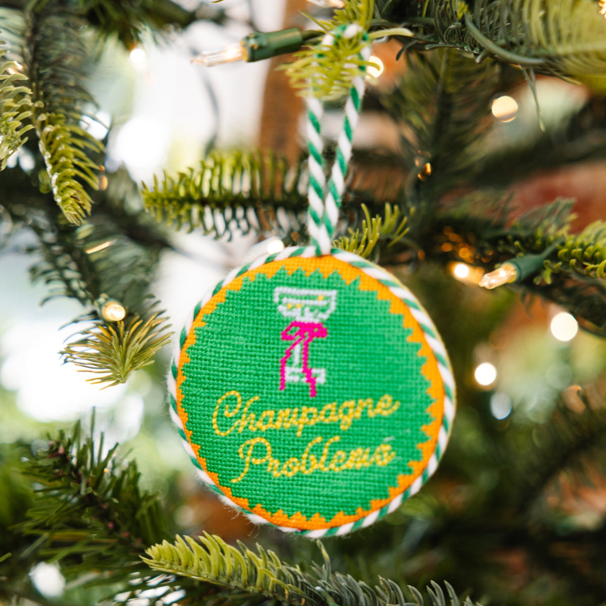 Decorative ornament with 'Champagne Problems' text on a Christmas tree.