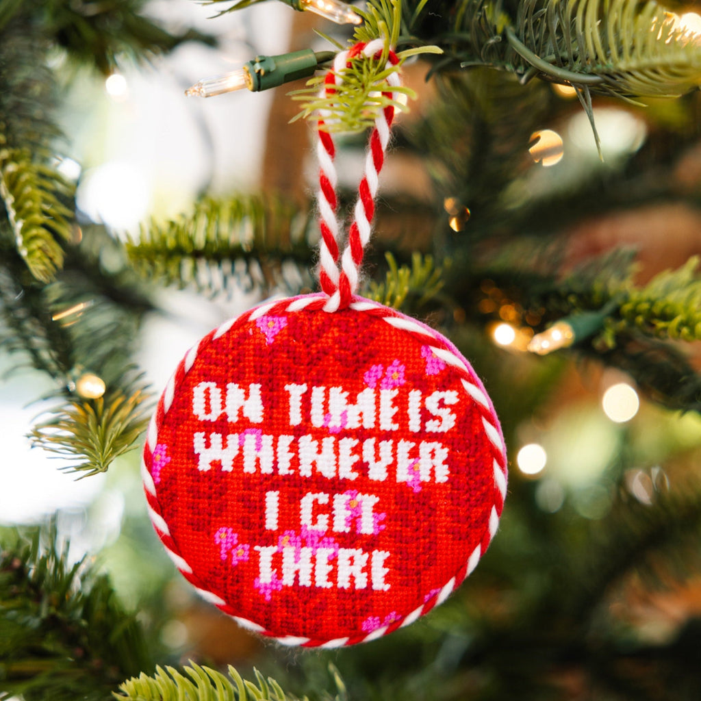 Red ornament with text hanging on a Christmas tree