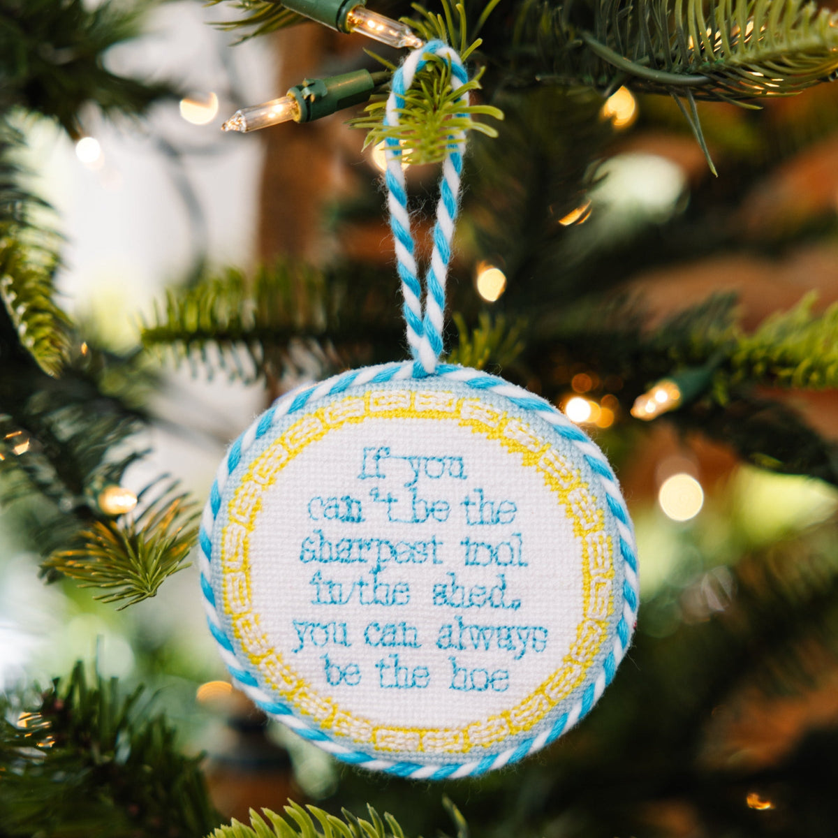 Decorative Christmas ornament with a humorous quote on a Christmas tree.