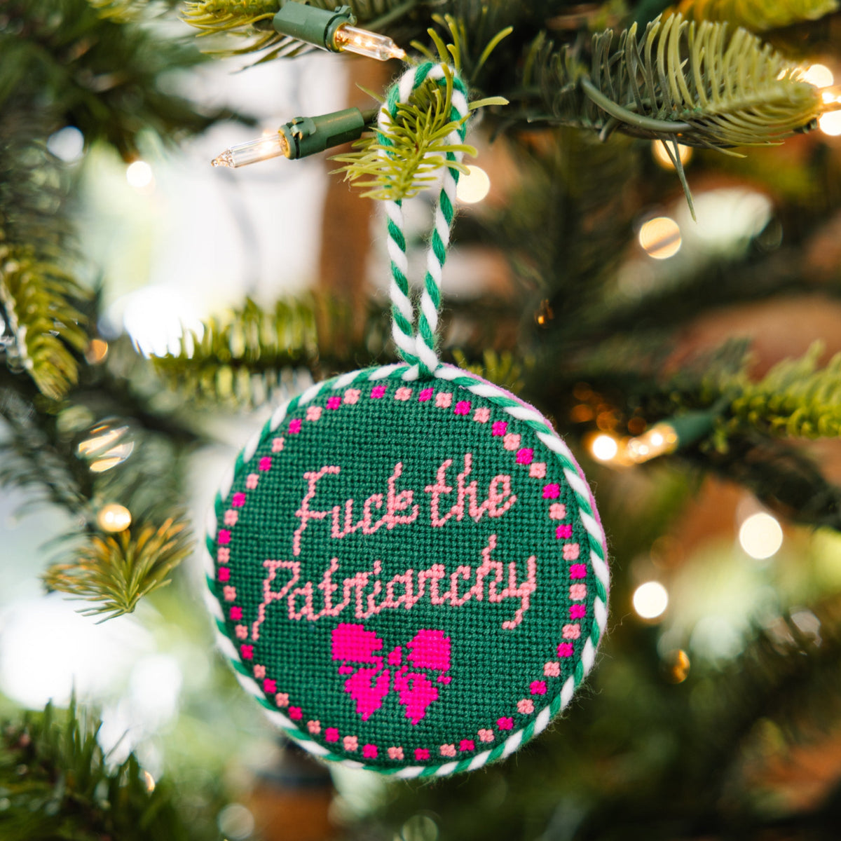 Ornament with text and design hanging on a Christmas tree