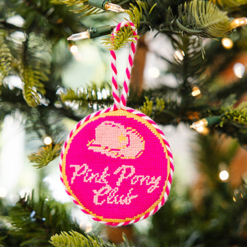Pink ornament with 'Pink Pony Club' text on a Christmas tree