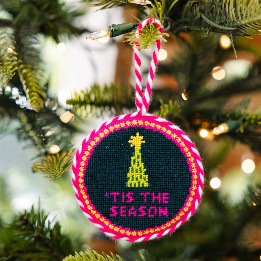 Decorative Christmas ornament with 'Tis the Season text on a Christmas tree.