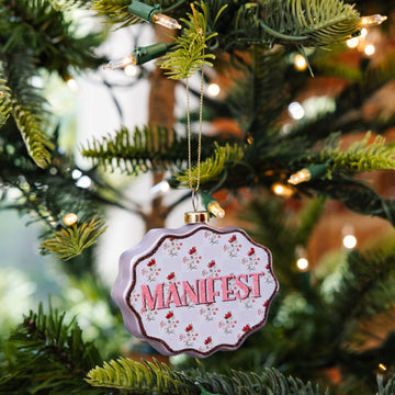Decorative ornament with 'Manifest' on a Christmas tree
