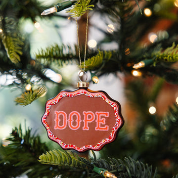 Decorative ornament with 'DOPE' text on a Christmas tree