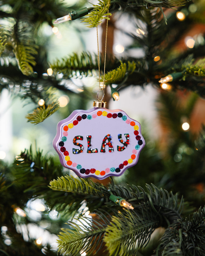 Decorative ornament with 'SLAY' text on a Christmas tree