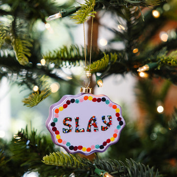 Decorative ornament with 'SLAY' text on a Christmas tree