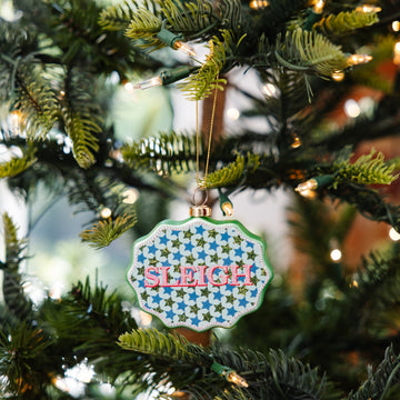Decorative ornament with 'SLEIGH' text on a Christmas tree