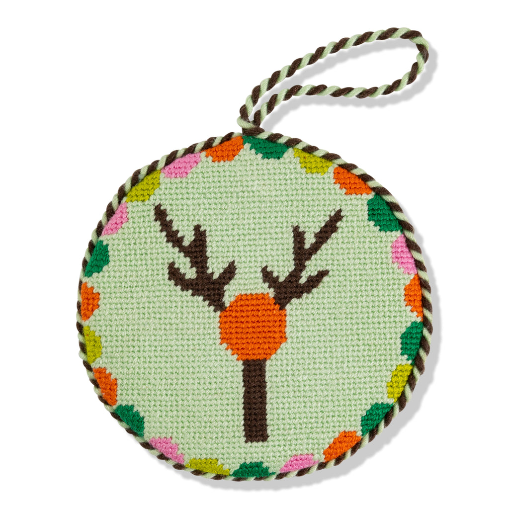 Round needlepoint ornament with deer design on a light green background