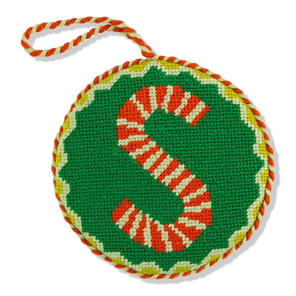 Crocheted letter 'S' with candy cane pattern on a green background