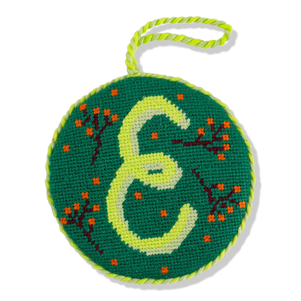 Circular embroidered item with letter 'E' on a green background