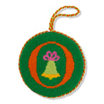 Circular embroidered ornament with a bell and bow design on a green background