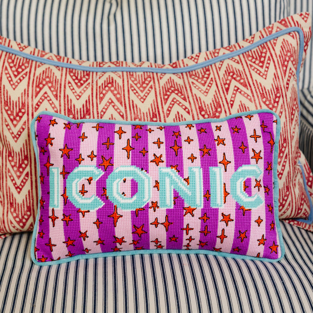 Decorative pillow with 'ICONIC' text on a striped background