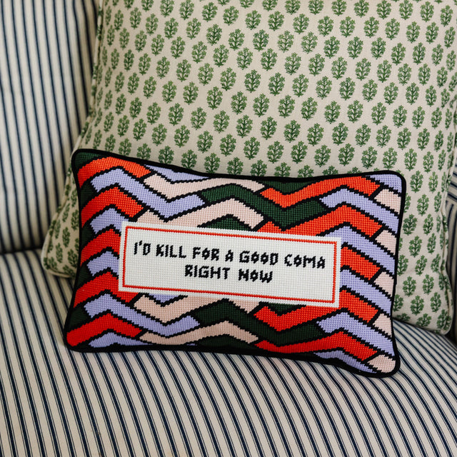 Decorative pillow with colorful zigzag pattern and text on a striped sofa.