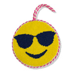 Round yellow toy with smiley face and sunglasses design, pink and white rope handle on a white background