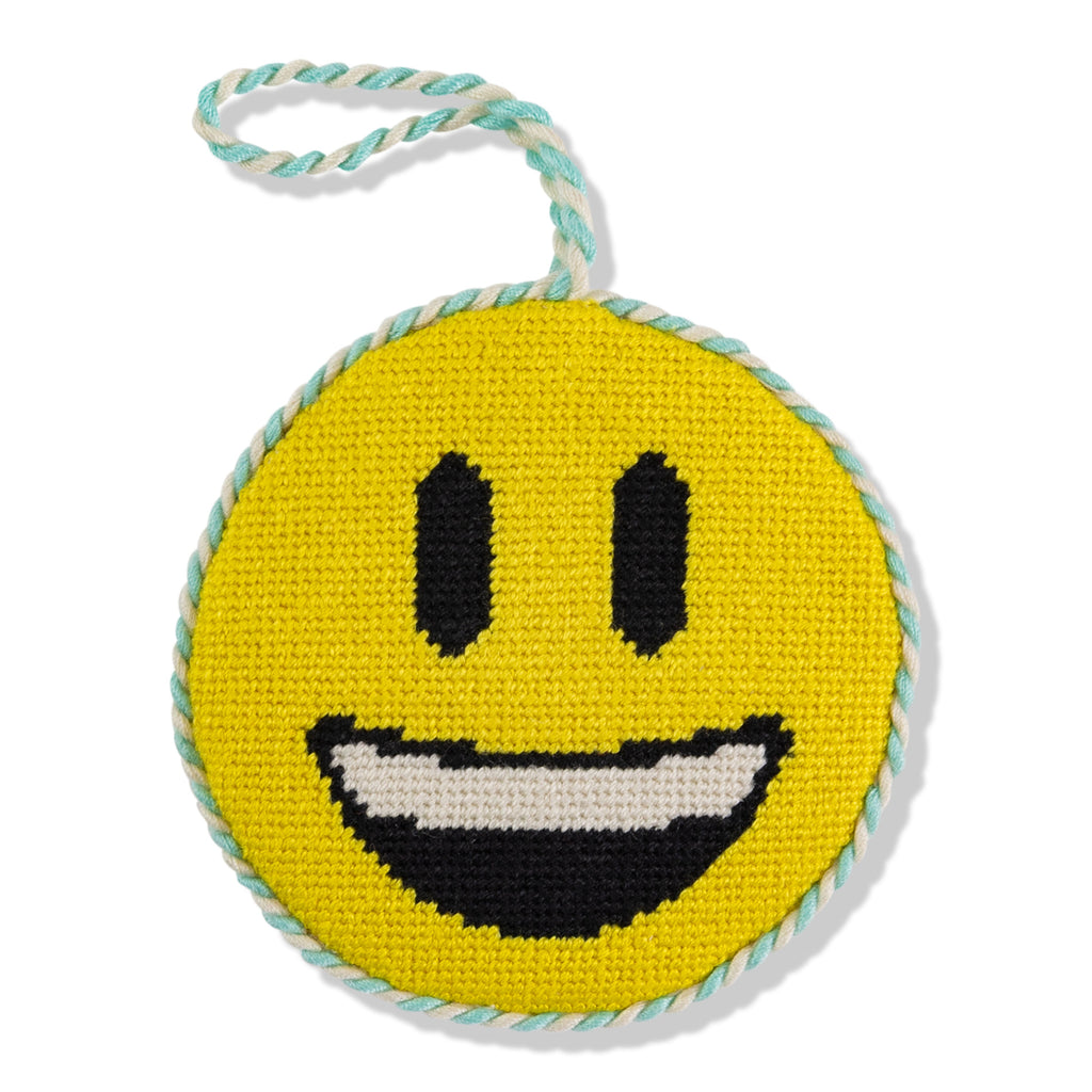 Round yellow smiley face toy with black eyes and mouth, on a white background