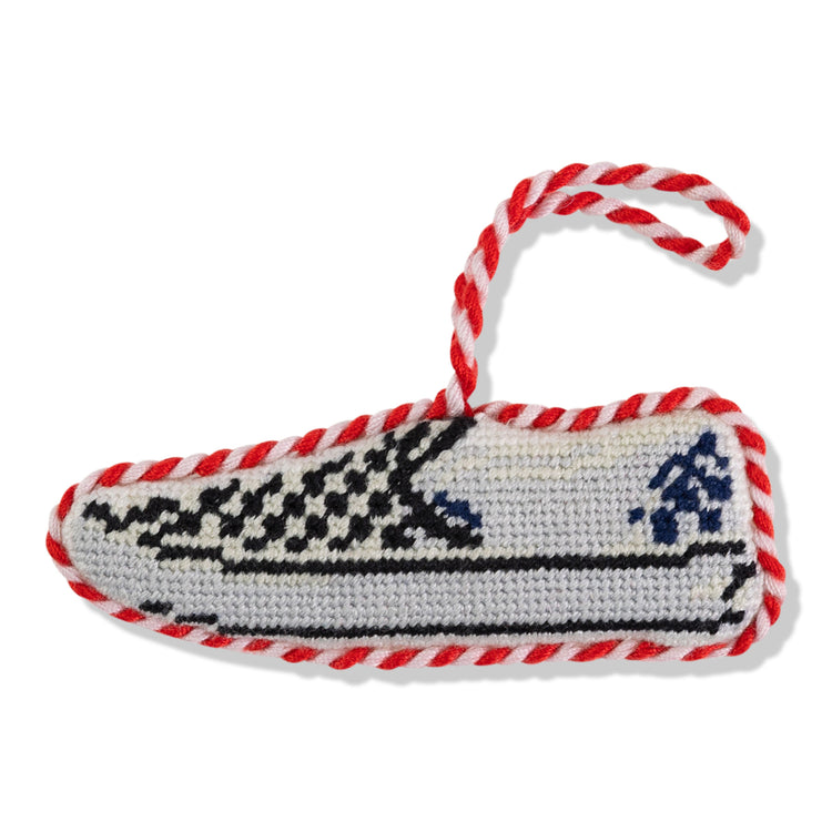 Hand-crocheted slipper with red and white trim on a white background