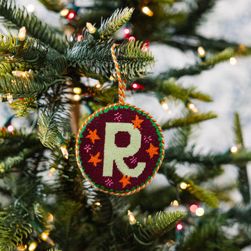 Decorative ornament with a letter 'R' on a Christmas tree