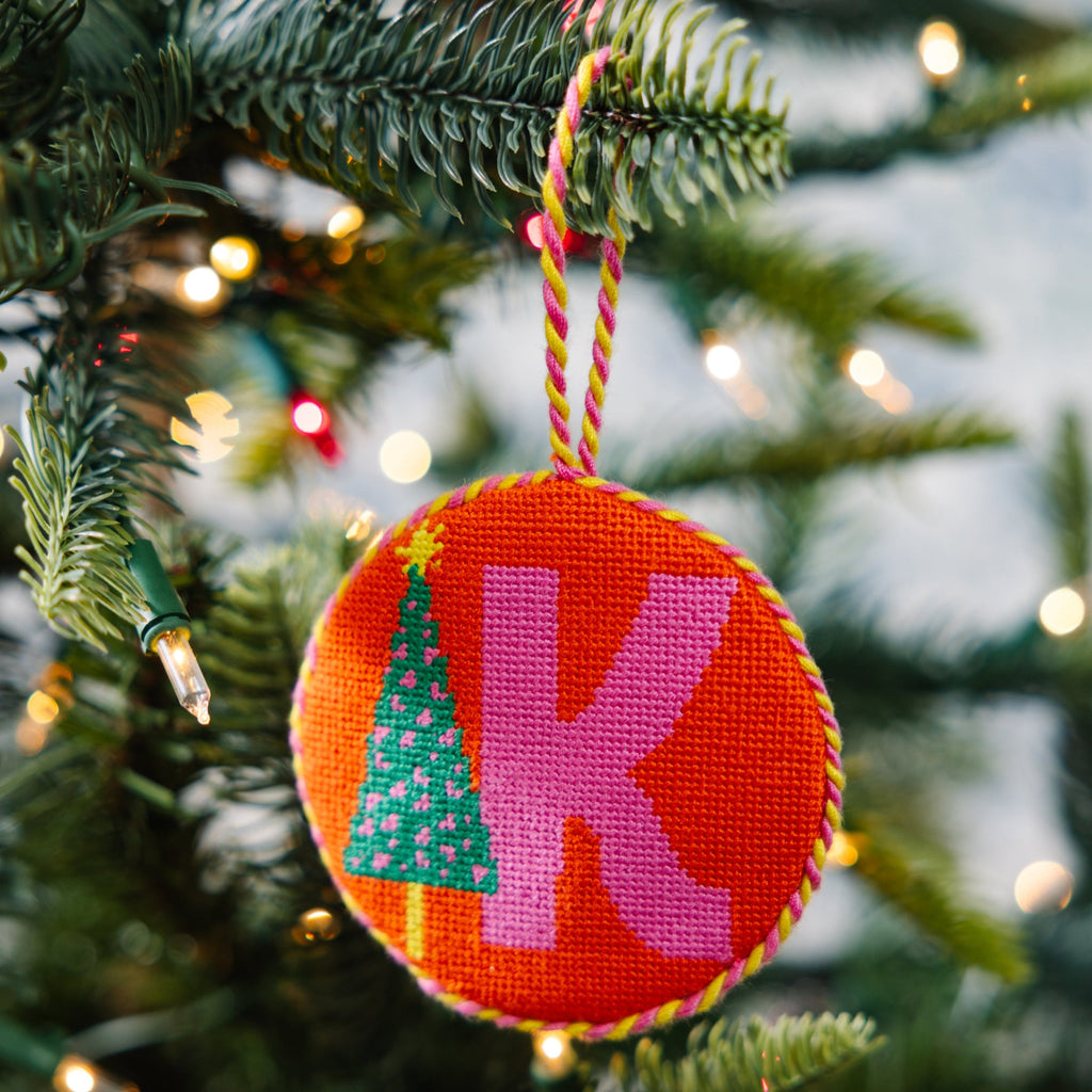 Decorative Christmas ornament with letter 'K' hanging on a tree