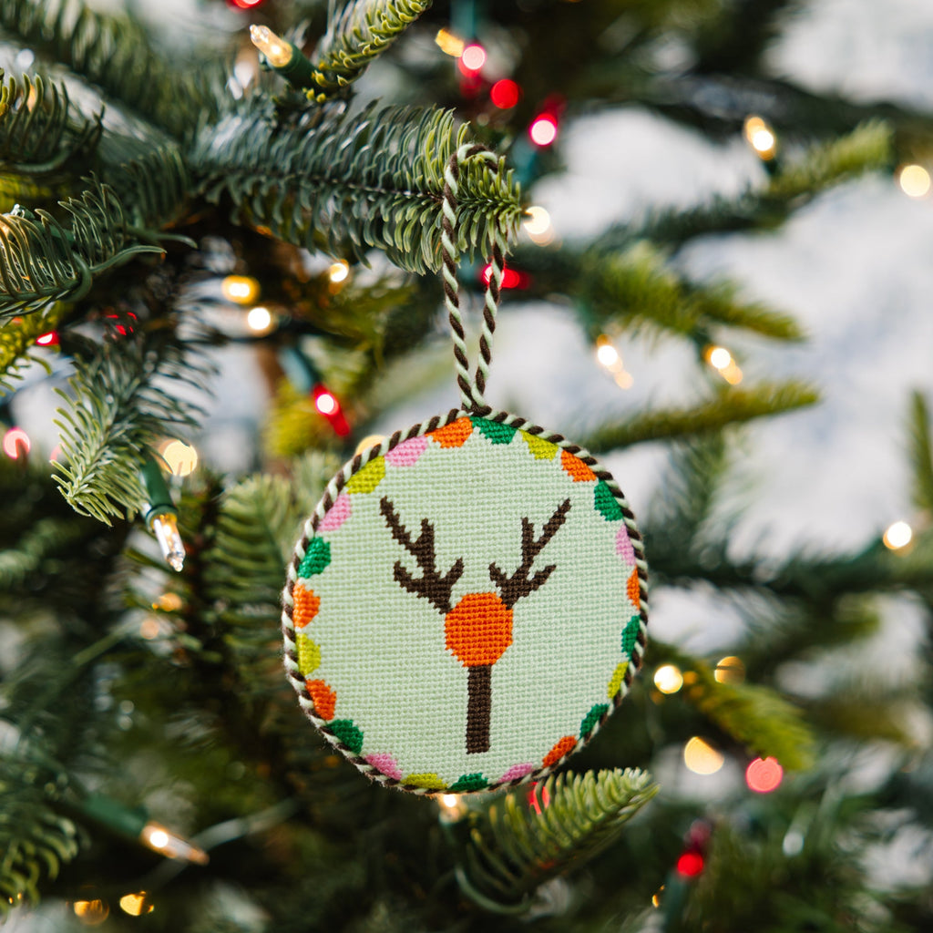 Decorative Christmas ornament with a deer design on a Christmas tree.