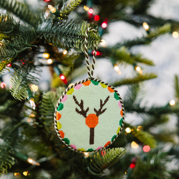 Decorative Christmas ornament with a deer design on a Christmas tree.