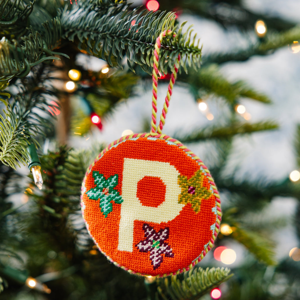 Decorative Christmas ornament with letter 'P' hanging on a tree